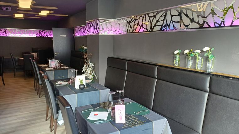 Elegantes Restaurant mit modernen Tischen und einer stilvollen Dekoration. Sanftes Licht und Blumenarrangements schaffen eine einladende Atmosphäre.