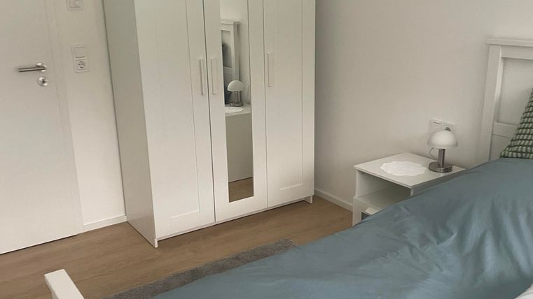 Der Kleiderschrank im Schlafzimmer ist mit einem Spiegel ausgestattet und bietet ausreichend Platz für Kleidung und persönliche Gegenstände.