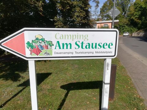 Ein Schild zeigt den Weg zum Campingplatz "Am Stausee". Der Platz bietet Dauer- und Touristen-Camping sowie Mobilstellplätze.
