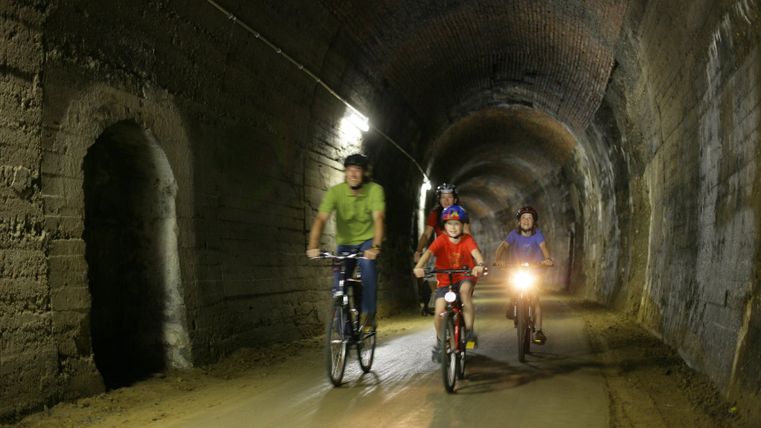 Radfahrer durchqueren einen Tunnel auf dem Eifel-Ardennen-Radweg.
