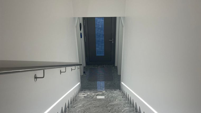 Vom Erdgeschoss aus gelangen Sie über eine edle Marmortreppe in die Ferienwohnung. Die hochwertige Verarbeitung und die großzügige Beleuchtung schaffen einen hellen, einladenden und stilvollen Zugang.