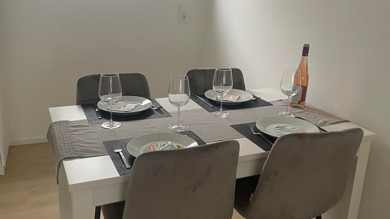 Ein moderner Essbereich direkt neben der Küche mit einem großen Tisch und 4 Stühlen.