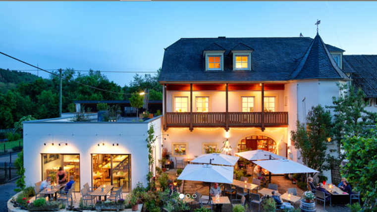 Ein einladendes Weinrestaurant mit Blick auf Weinreben und einer entspannten Atmosphäre. Die Speisekarte bietet hausgemachte Kuchen und erlesene Weine.