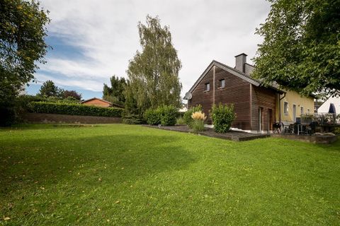 Ein modernes Haus inmitten eines grünen Gartens. Umgeben von Bäumen und Sträuchern bietet es einen ruhigen Rückzugsort.