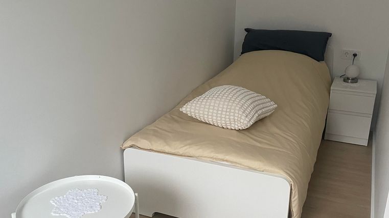 Das zweite Schlafzimmer ist kleiner, verfügt über ein Bett (0,90 m), ein Nachtisch mit Lampe sowie eine Kommode und ein Sessel.