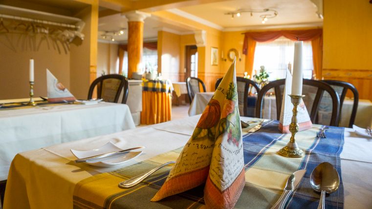 Ein schön gedeckter Tisch in einem eleganten Restaurant. Die Tischdekoration besteht aus gefalteten Servietten und Kerzen.